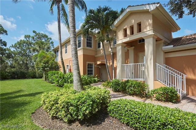 view of front facade with a front lawn and stucco siding