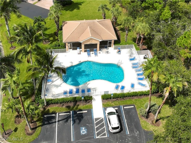 pool with a patio area and fence