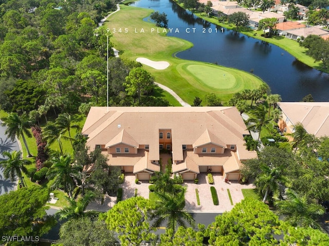 drone / aerial view with view of golf course and a water view