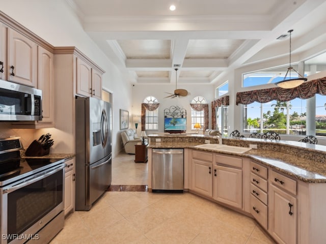 kitchen featuring light tile patterned floors, light brown cabinets, appliances with stainless steel finishes, beamed ceiling, and coffered ceiling