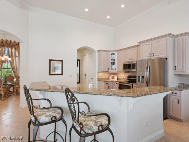 kitchen featuring crown molding, light tile patterned flooring, stainless steel appliances, and stone counters