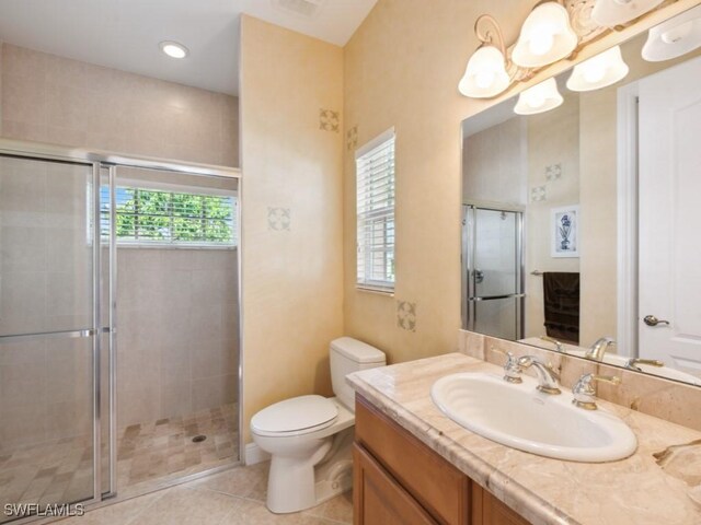 bathroom with tile patterned floors, walk in shower, vanity, and toilet