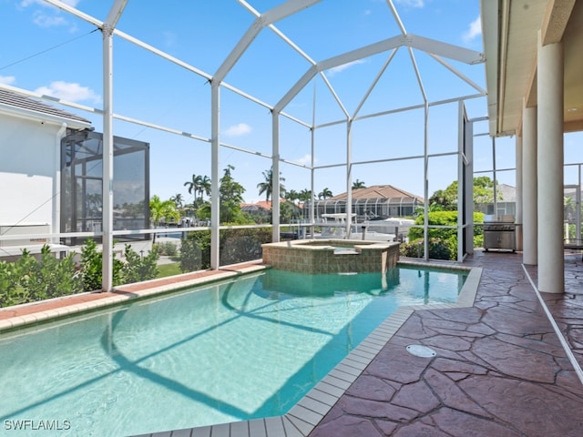 view of swimming pool featuring glass enclosure, a patio, and an in ground hot tub