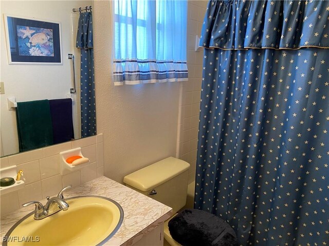 bathroom with vanity, tasteful backsplash, and toilet