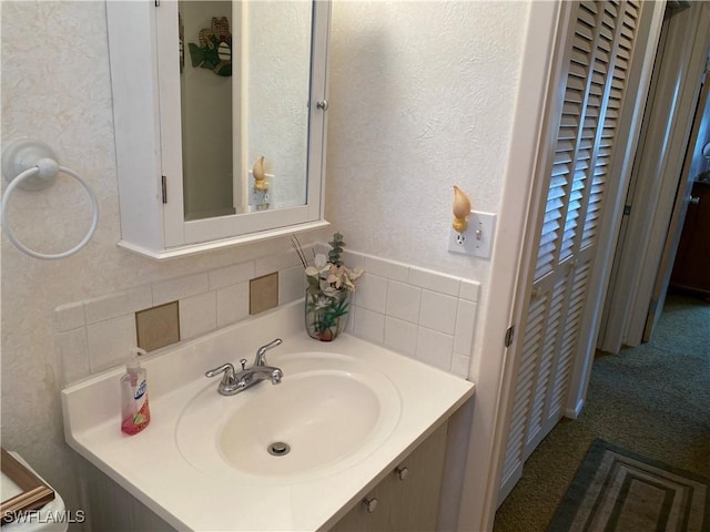 bathroom with vanity and tasteful backsplash