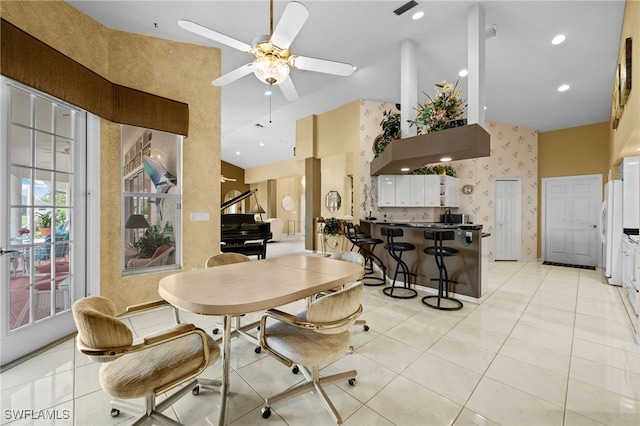 tiled dining space with a high ceiling and ceiling fan