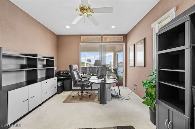 home office featuring ceiling fan, recessed lighting, a textured wall, and light carpet