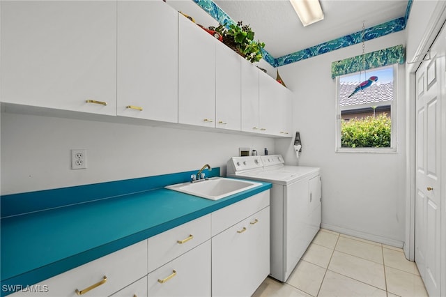 laundry room featuring washing machine and dryer, sink, light tile patterned floors, and cabinets