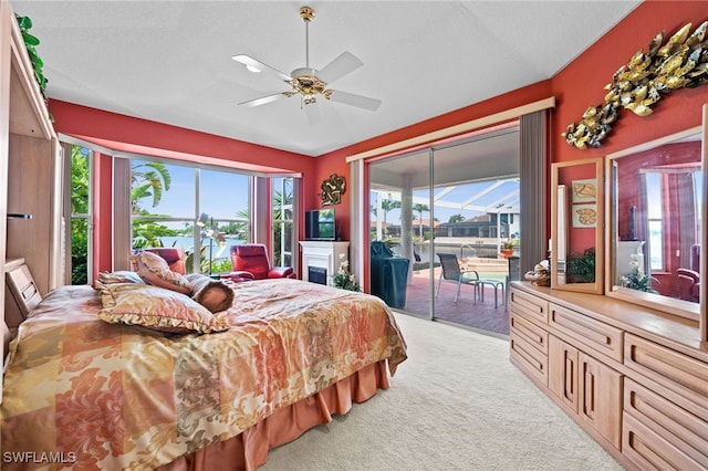 carpeted bedroom featuring ceiling fan, a textured ceiling, access to outside, and multiple windows