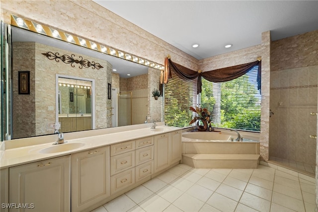 bathroom featuring tile patterned floors, a sink, a shower stall, double vanity, and a bath