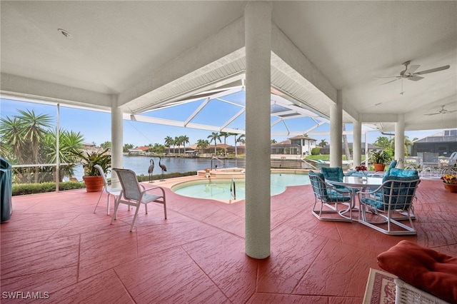 view of patio / terrace featuring a water view, a ceiling fan, glass enclosure, an outdoor pool, and an in ground hot tub