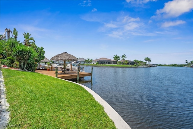 view of dock featuring a lawn and a water view