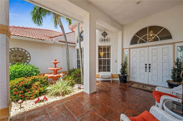 property entrance with stucco siding and a tile roof