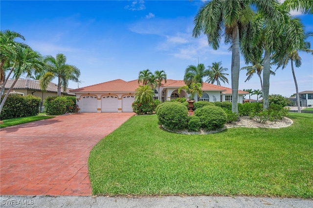 view of front of house featuring a garage, decorative driveway, a front lawn, and stucco siding