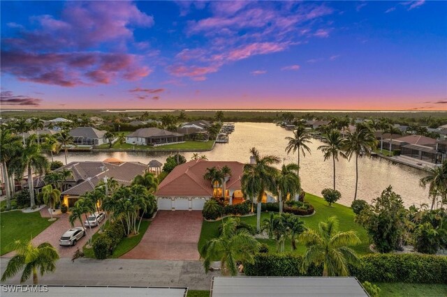 aerial view at dusk featuring a water view