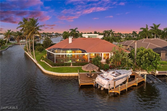 view of dock featuring boat lift, glass enclosure, and a water view