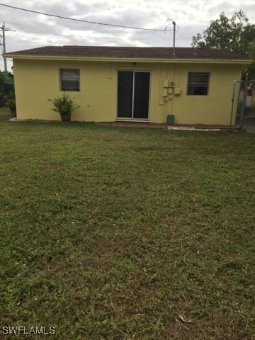 back of property featuring a lawn