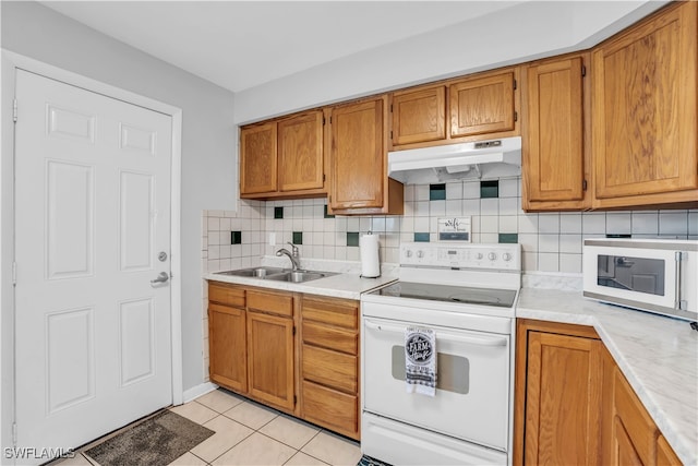 kitchen featuring decorative backsplash, sink, white appliances, and light tile patterned floors