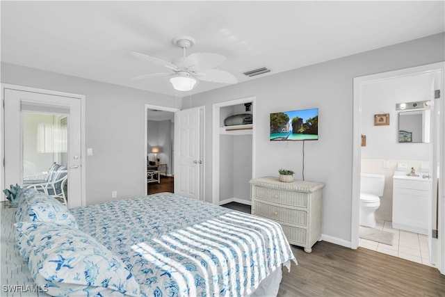 bedroom featuring hardwood / wood-style flooring, ensuite bath, and ceiling fan