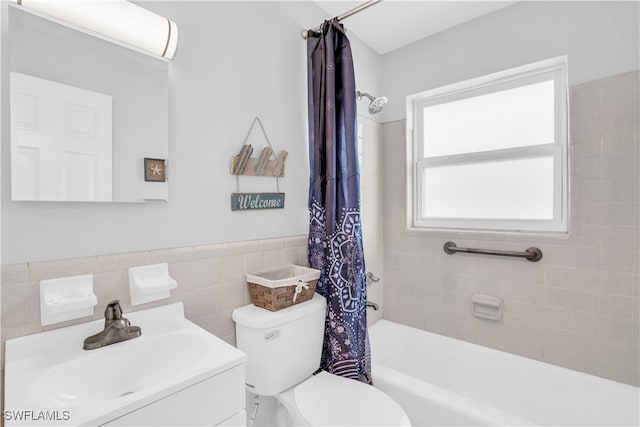 full bathroom featuring shower / tub combo, tile walls, decorative backsplash, toilet, and vanity