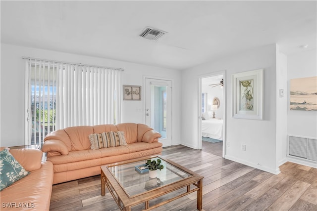 living room featuring a wealth of natural light, light wood-type flooring, and ceiling fan