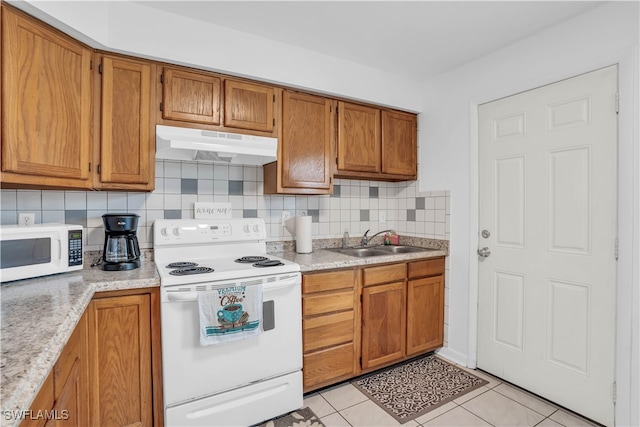 kitchen with light tile patterned flooring, sink, tasteful backsplash, and white appliances