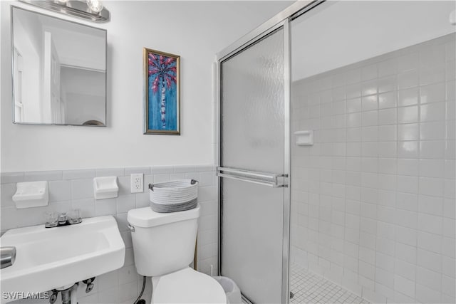 bathroom with a shower with shower door, toilet, tile walls, decorative backsplash, and sink