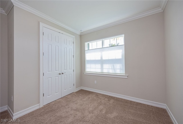 unfurnished bedroom with light carpet, crown molding, and a closet