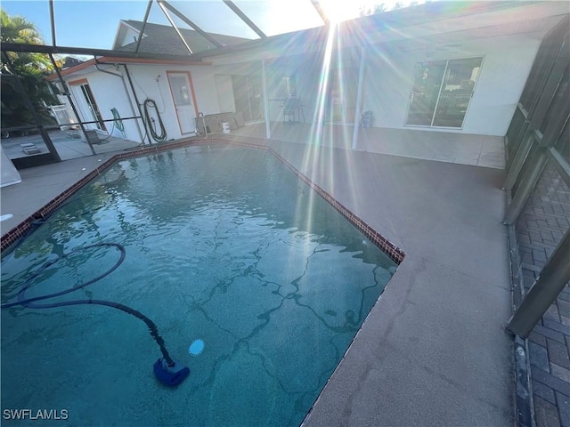 pool featuring a patio and glass enclosure