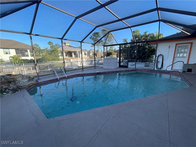 outdoor pool with glass enclosure, a patio, and fence