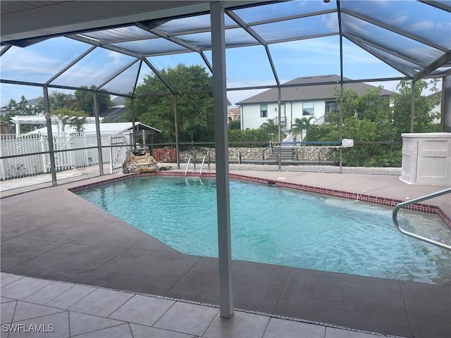 outdoor pool featuring glass enclosure, a patio, and fence