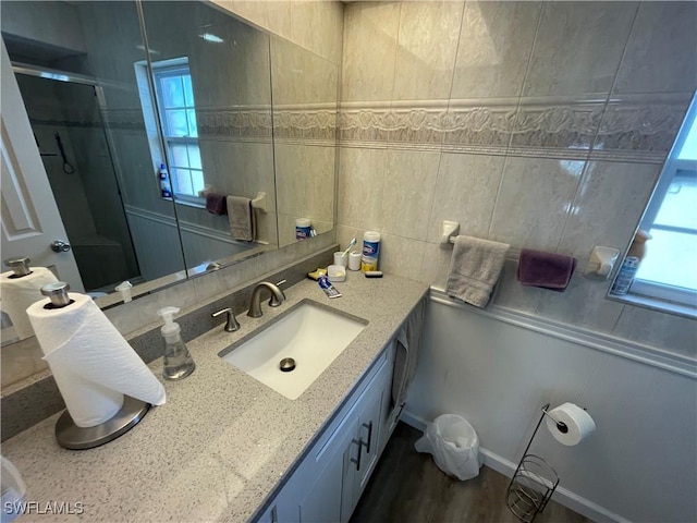 bathroom featuring a shower stall, vanity, and decorative backsplash