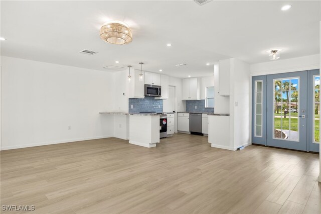 kitchen featuring appliances with stainless steel finishes, white cabinetry, light wood-type flooring, and kitchen peninsula