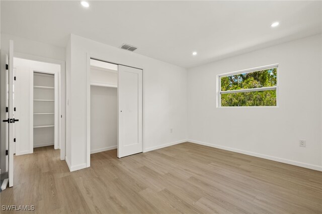 unfurnished bedroom featuring light hardwood / wood-style flooring and a closet