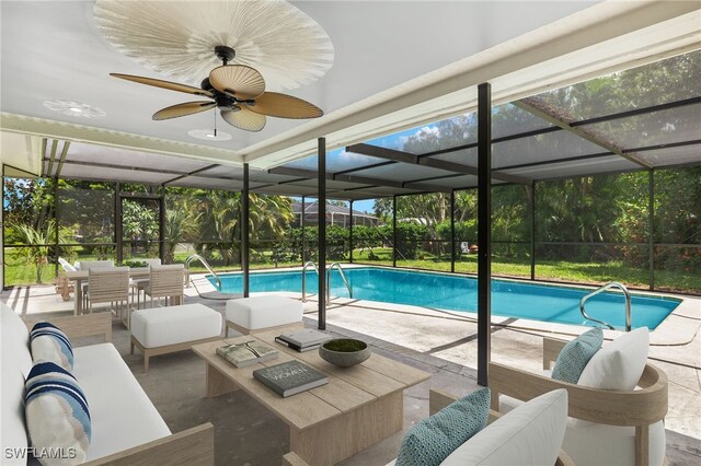 view of swimming pool with ceiling fan, glass enclosure, a patio area, and an outdoor living space