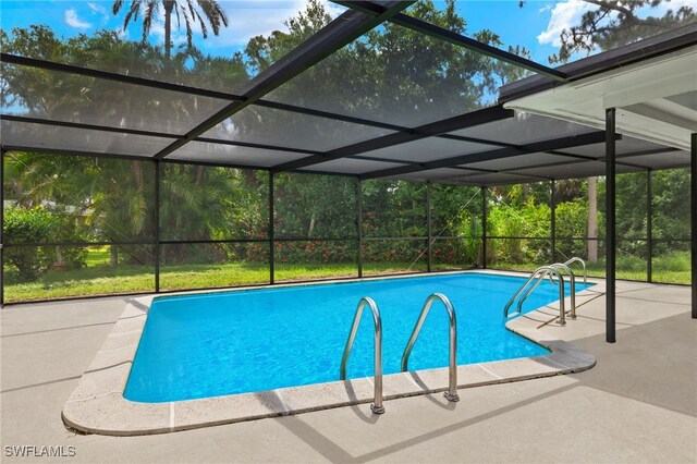 view of swimming pool featuring glass enclosure and a patio