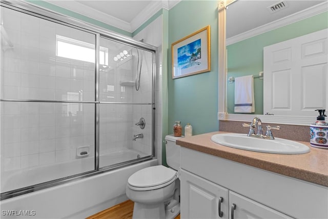 bathroom featuring vanity, visible vents, enclosed tub / shower combo, ornamental molding, and toilet