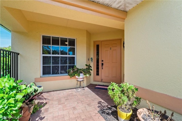 doorway to property featuring stucco siding