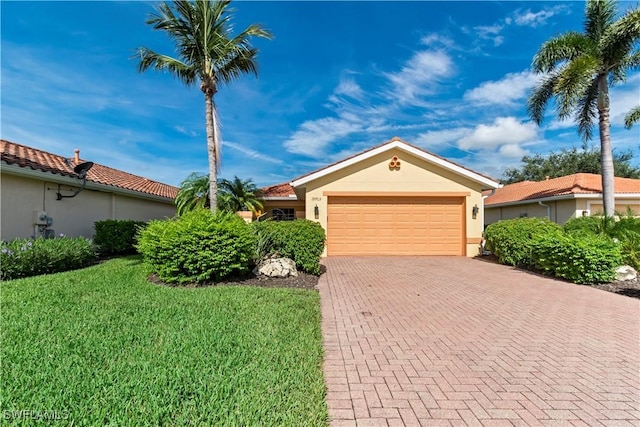 view of front facade featuring a front lawn, a tile roof, stucco siding, decorative driveway, and an attached garage