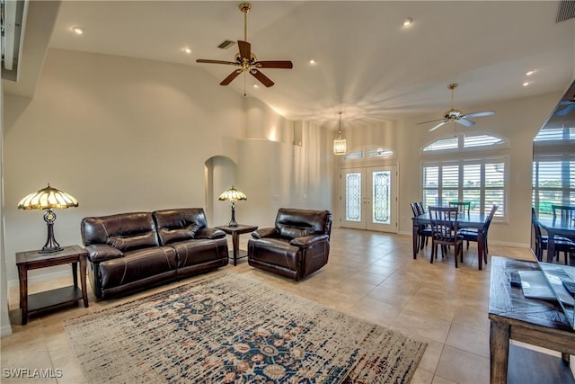 living room with light tile patterned floors, high vaulted ceiling, french doors, and a healthy amount of sunlight