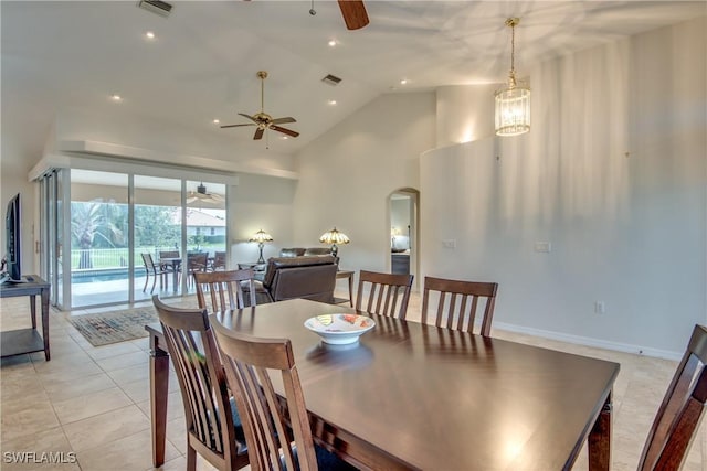 dining area featuring arched walkways, high vaulted ceiling, light tile patterned flooring, and visible vents