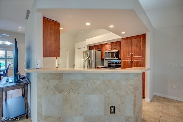 kitchen with visible vents, brown cabinetry, a peninsula, stainless steel appliances, and light countertops