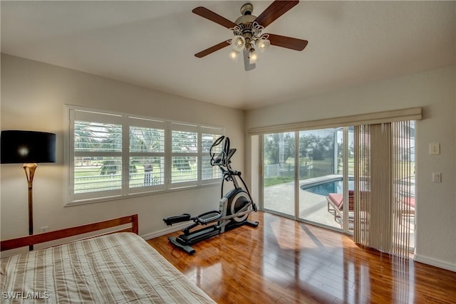 workout room featuring ceiling fan, baseboards, and wood finished floors