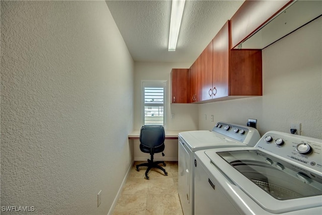 clothes washing area with a textured ceiling, a textured wall, separate washer and dryer, baseboards, and cabinet space