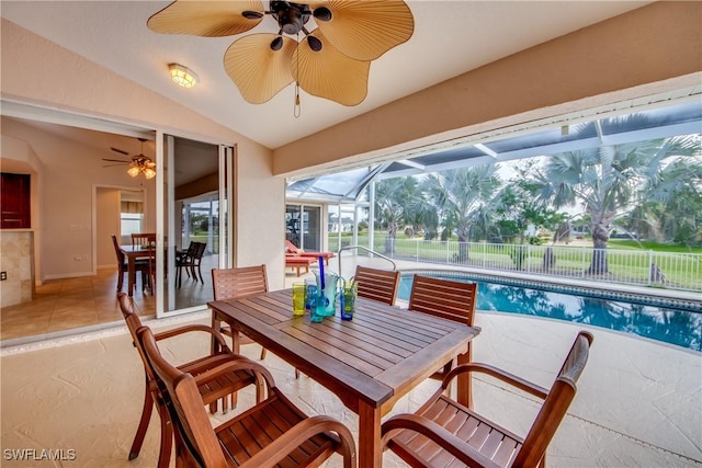 sunroom with lofted ceiling and a ceiling fan