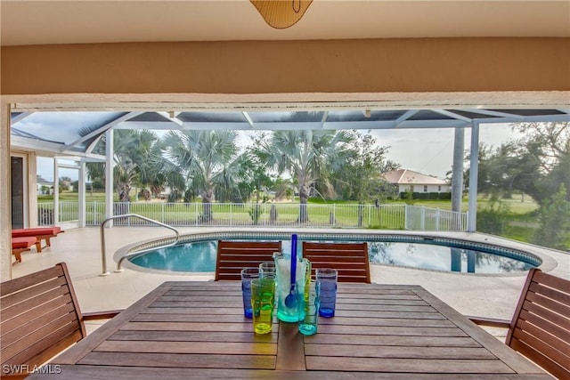 pool with glass enclosure, a fenced backyard, a patio, and outdoor dining space