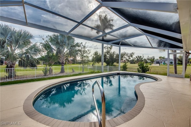 pool with a lanai, a patio area, and fence