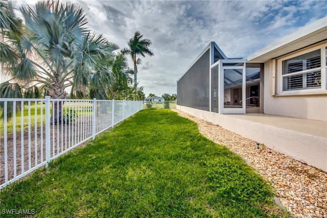 view of yard with a lanai and fence