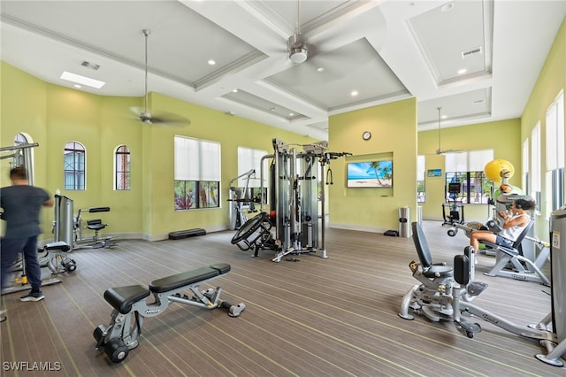 workout area featuring ceiling fan, crown molding, carpet floors, and coffered ceiling