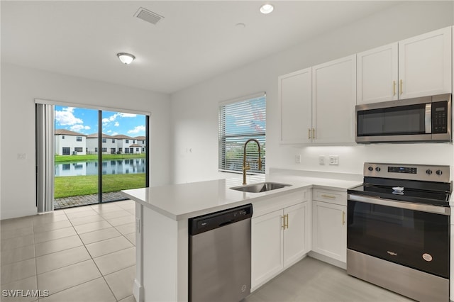 kitchen with a wealth of natural light, sink, stainless steel appliances, and a water view